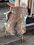 Brown fluffy tibet highland spotted sheepskin rug draped over white wooden chair showcasing soft texture