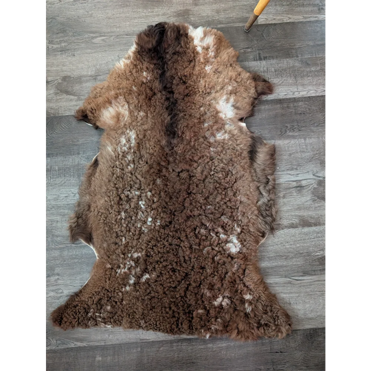 Brown and white tibet highland spotted sheepskin rug with plush curly texture perfect for cozy decor