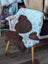 Cozy white and brown tibet highland spotted grade a- sheepskin chair cover draped over wooden armchair frame