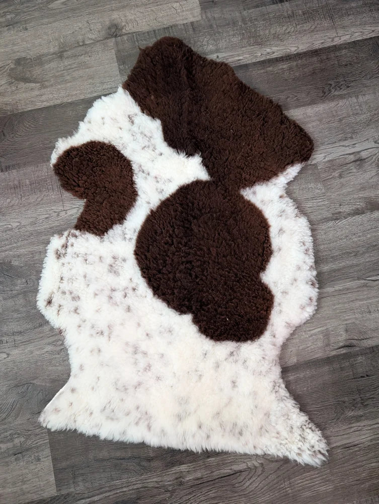 A plush grade a- sheepskin rug with white and brown tibet highland spotted pattern and soft fluffy texture