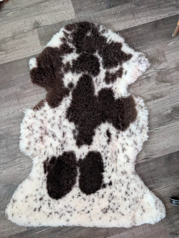 A plush tibet highland spotted grade a sheepskin rug in natural white and dark brown by nat’s grade