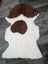 A plush white and brown tibet highland spotted grade a- sheepskin rug with a fluffy natural texture from nat’s grade