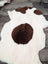 A plush white and brown tibet highland spotted grade a- sheepskin rug with natural fluffy texture from nat’s grade