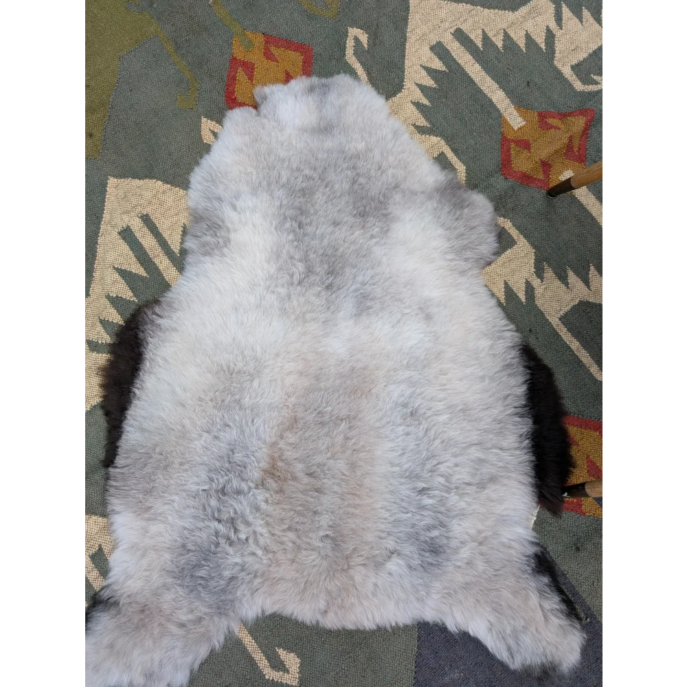 A soft fluffy gray long wool icelandic sheepskin rug with natural mottled texture by angus oliver