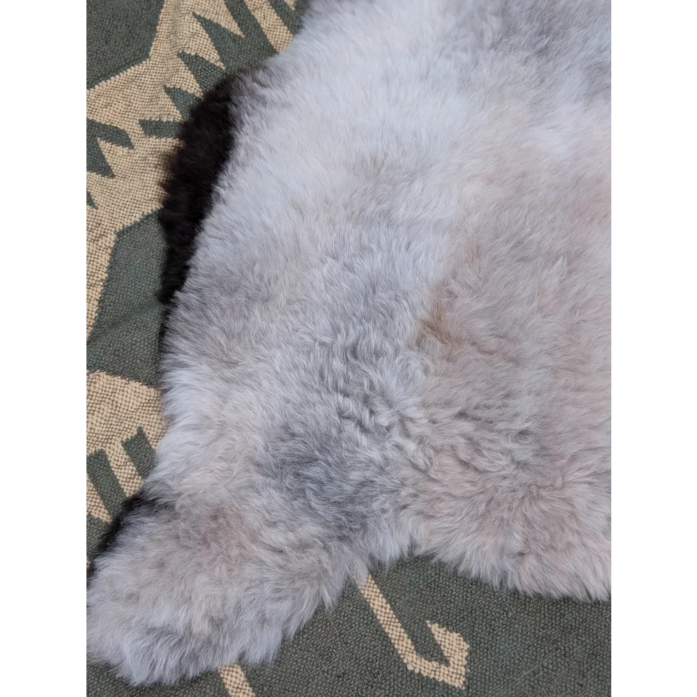A soft light gray large icelandic sheepskin rug with long wool and natural texture by angus oliver