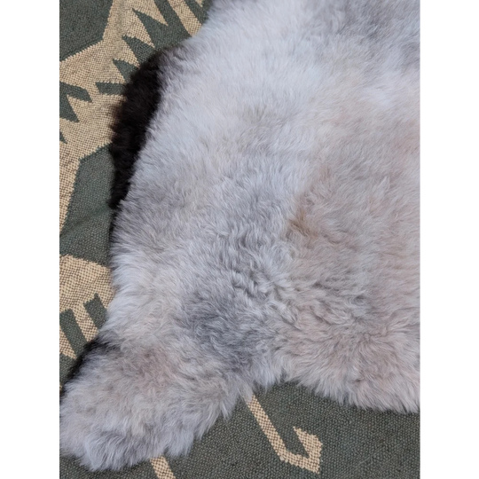 A soft light gray large icelandic sheepskin rug with long wool and natural texture by angus oliver