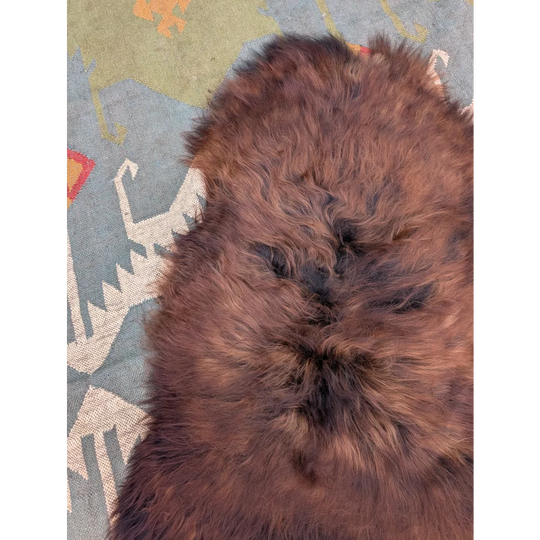 A plush brown wool icelandic sheepskin rug with soft dense texture and natural shade variations, 50 x 27 inches