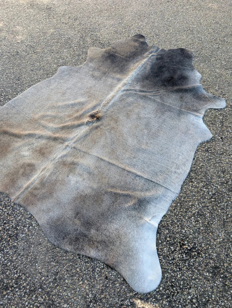 Sun1 large cowhide rug with natural gray and black tones and soft textured surface showing unique characteristics
