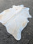 Large lovely cowhide rug in white with natural tan and light brown markings showcasing unique characteristics
