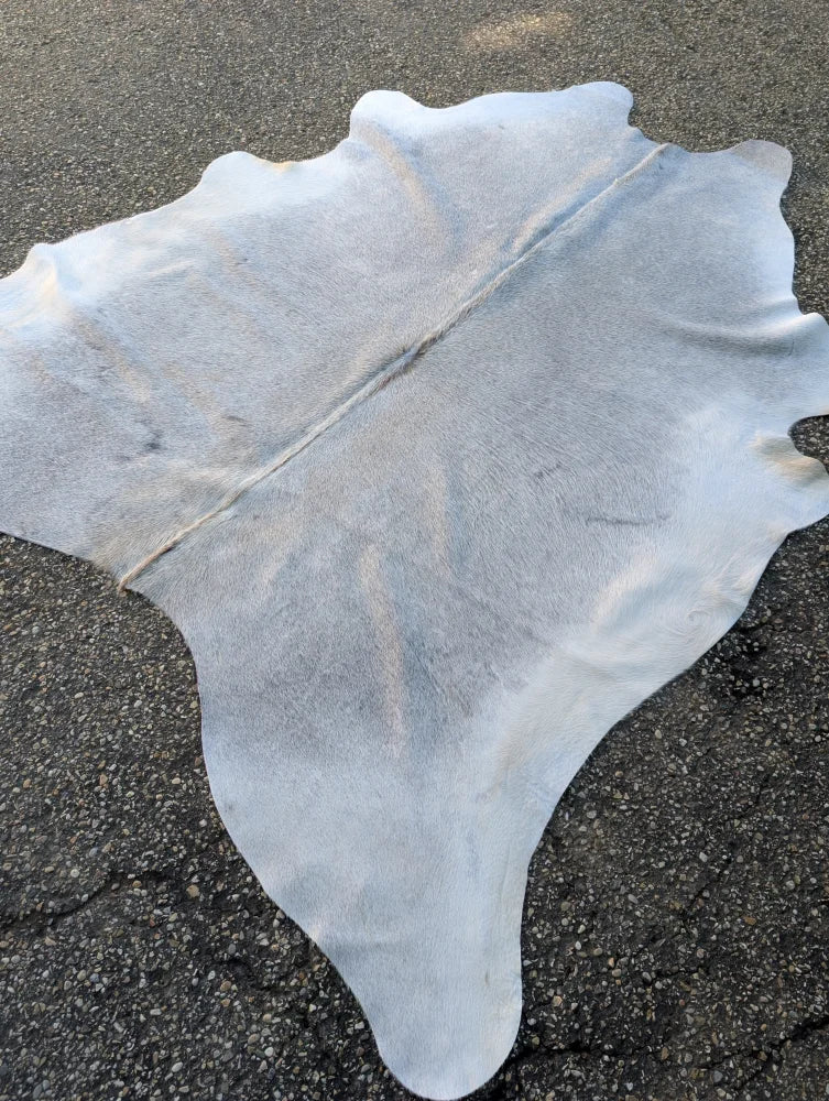 Large lovely grey cowhide rug with natural texture and unique characteristics measuring 78 by 70 inches