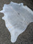 Large light gray lovely cowhide rug with naturally textured surface and unique characteristics measuring 78 x 70 inches