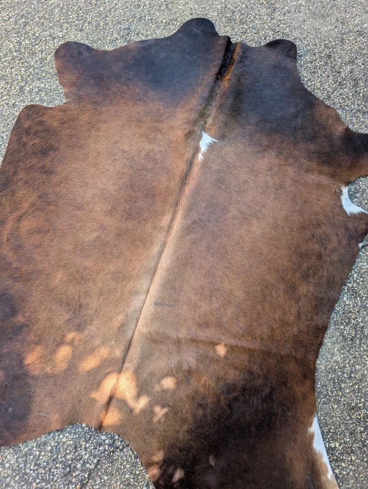 Brown and white large cowhide rug with natural fur texture featuring unique characteristics and lovely cowhide rug style