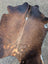 Brown and white large cowhide rug with natural fur texture featuring unique characteristics and lovely cowhide rug style