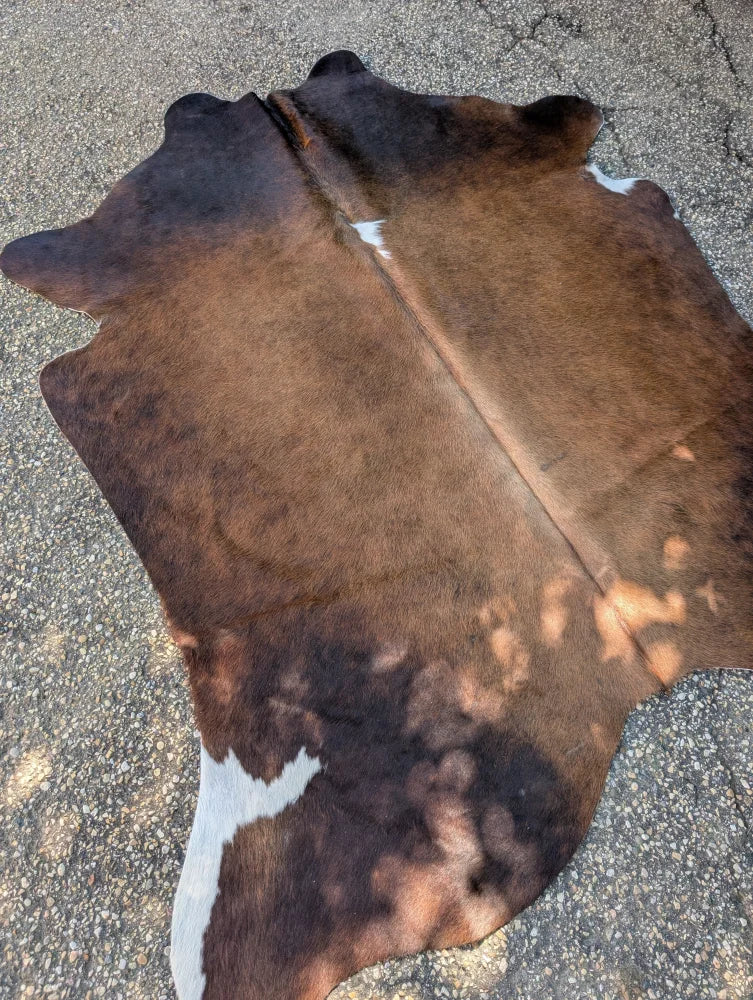 Large lovely cowhide rug in brown and white with natural fur texture showcasing unique characteristics