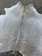 Large lovely grey cowhide rug with soft textured surface and visible stitching showcasing unique characteristics
