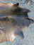 Large cowhide rug in brown and black with natural fur texture showing unique characteristics for stylish decor