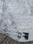Gray speckled large cowhide with black graffiti markings showcasing unique characteristics in a lovely cowhide rug