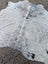 Large gray and white speckled cowhide rug with natural irregular edge showcasing unique characteristics