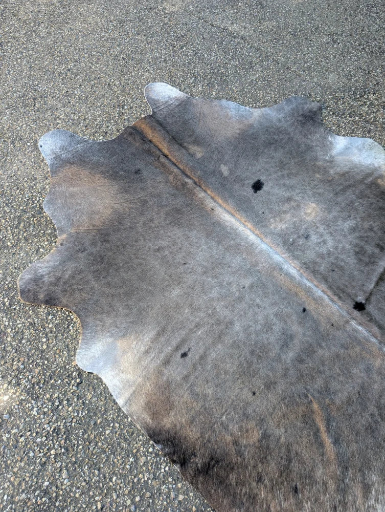 Sun2 large cowhide rug in dark gray and brown with unique characteristics and a lovely textured surface