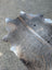 Sun2 large cowhide rug in dark gray and brown with unique characteristics and a lovely textured surface