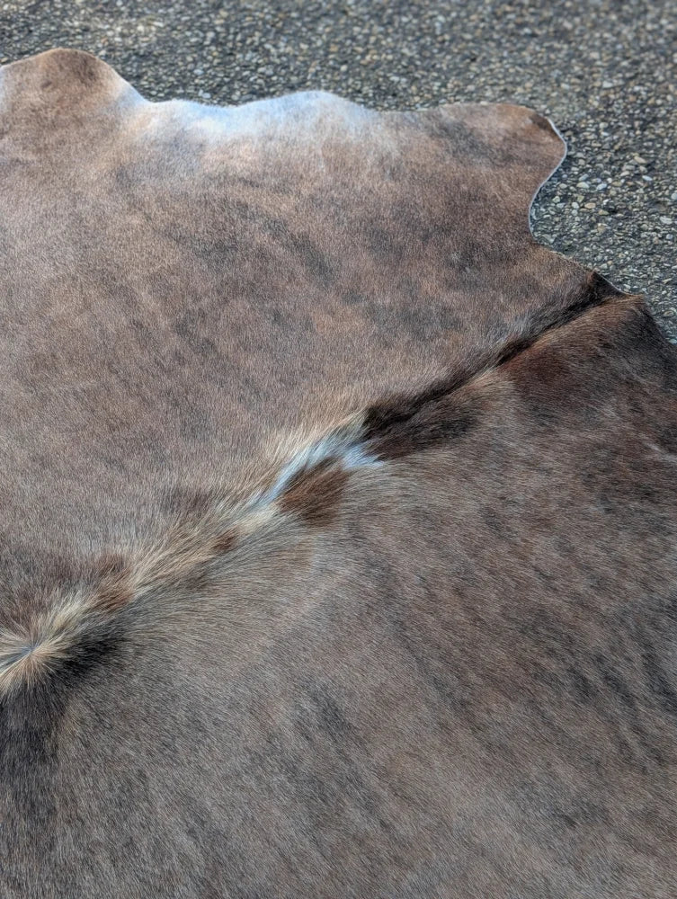 Large lovely cowhide rug with brown and gray natural fur texture showcasing unique characteristics