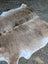 Large brown and white lovely cowhide rug with natural fur texture and unique characteristics for home decor