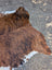 Large brown and white cowhide rug with natural fur texture featuring unique characteristics and lovely style design