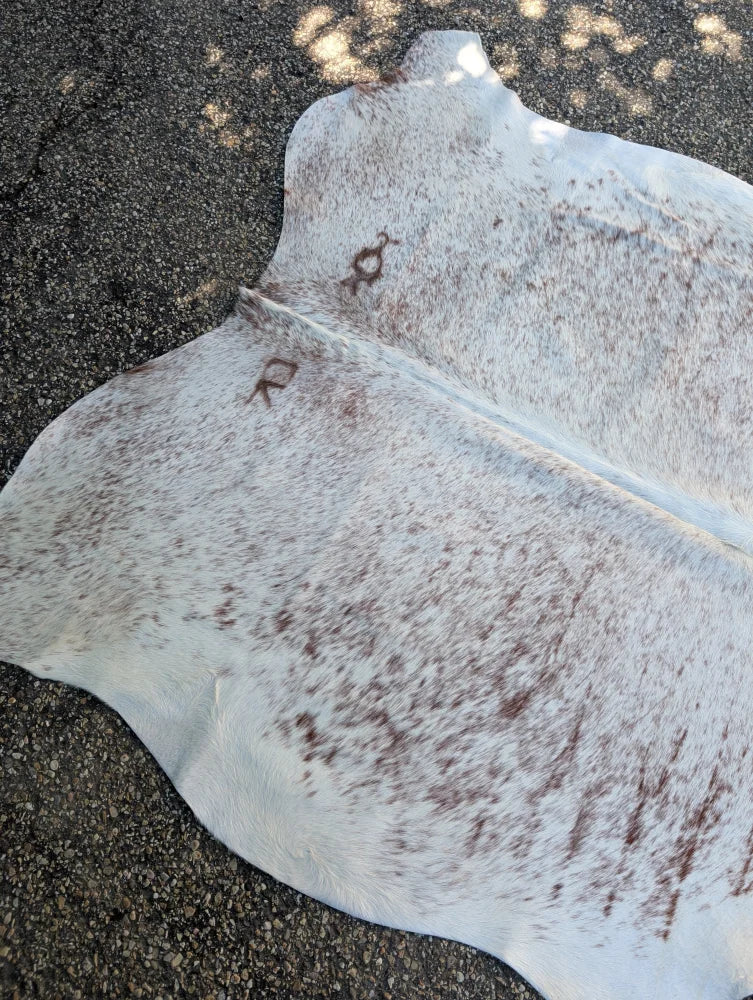 Large lovely cowhide rug in white and brown speckled natural fur texture with unique characteristics 84 x 66 inches