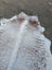 Large cowhide lovely cowhide rug in white and brown speckled pattern with unique characteristics and natural edge