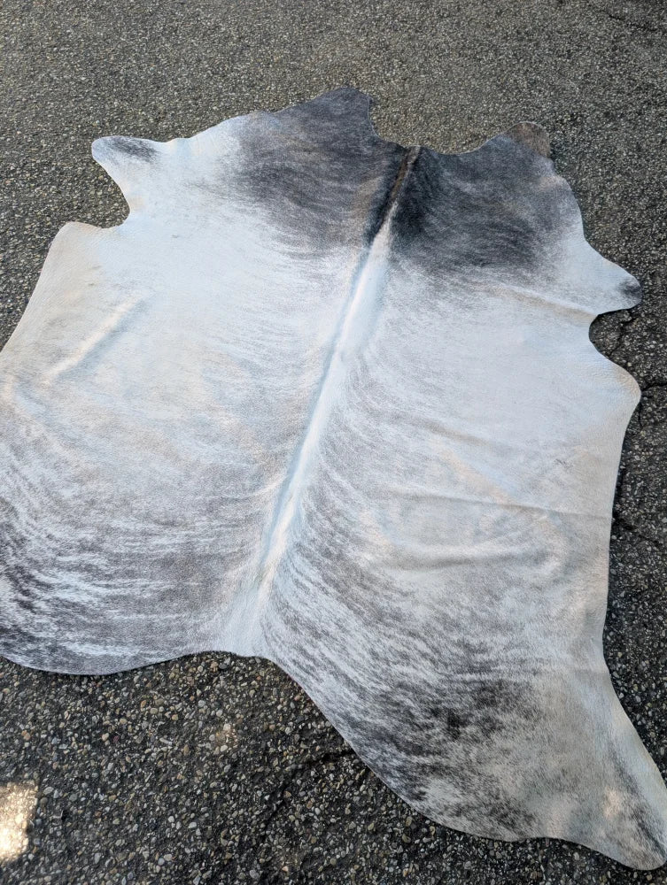 Large black and white cowhide rug with soft textured surface showcasing unique characteristics from sun8 collection