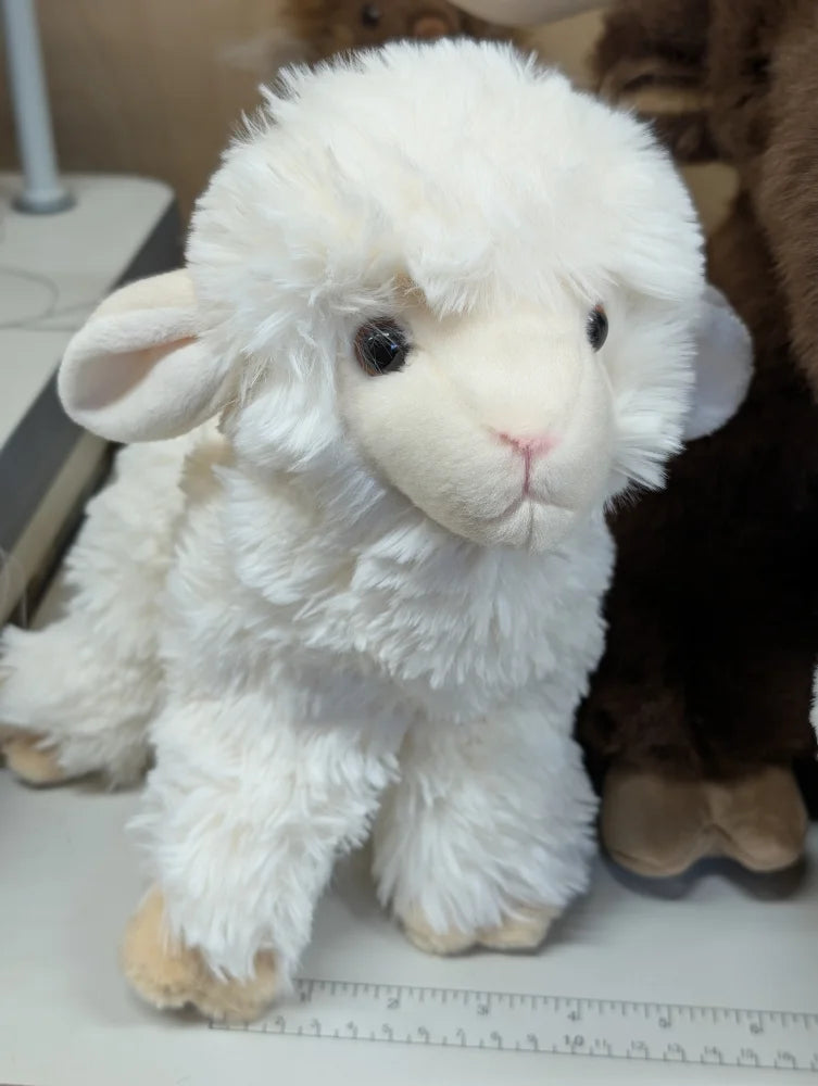 A super soft plush white lamb toy with fluffy fur and small black eyes perfect for cuddling and gifts