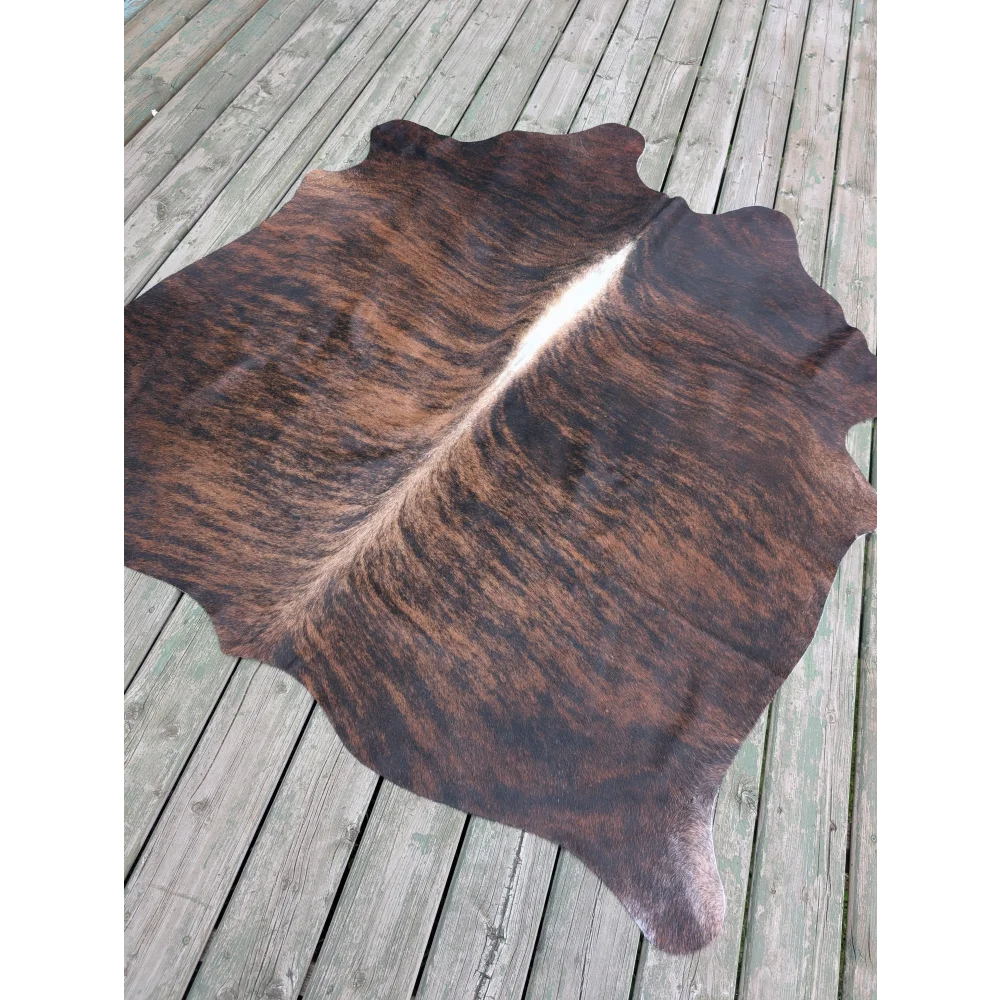 Large cowhide rug t1 with rich brown and black textures and a natural white stripe perfect for adding unique characteristics
