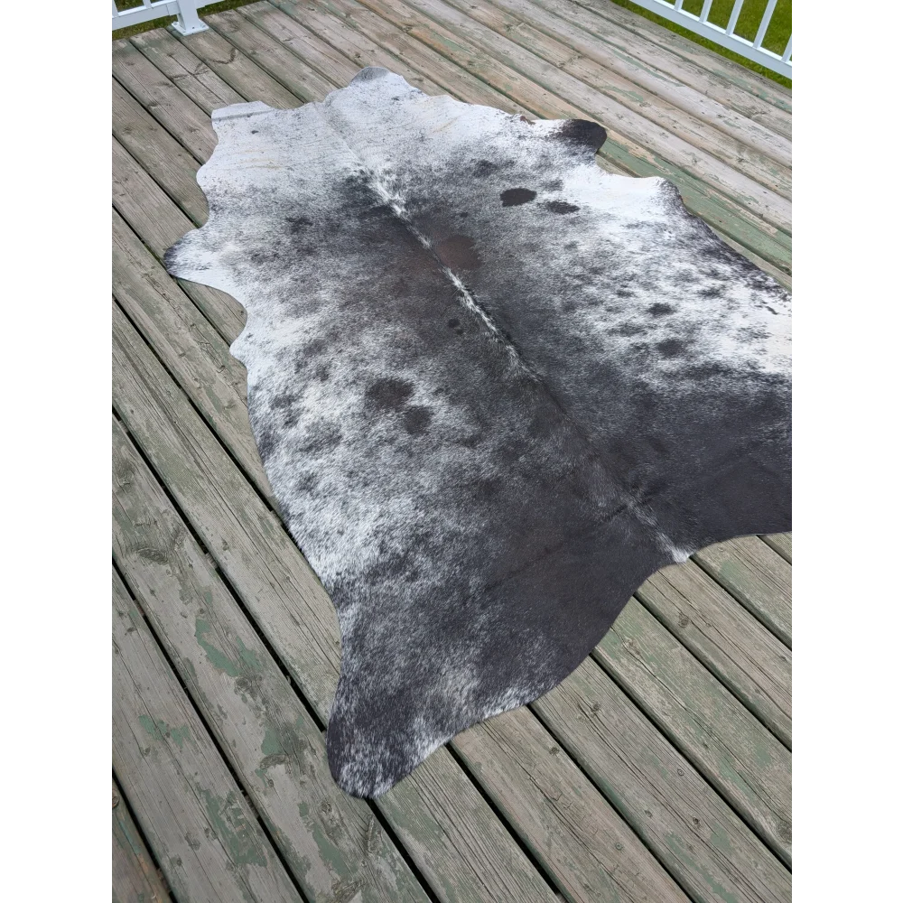 T10 81 x 61 gorgeous cowhide large black and white cowhide rug with natural fur texture showing unique characteristics on wood deck