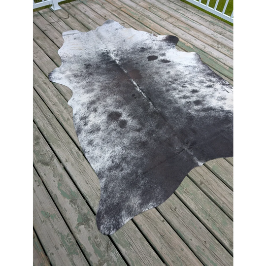 T10 81 x 61 gorgeous cowhide large black and white cowhide rug with natural fur texture showing unique characteristics on wood deck