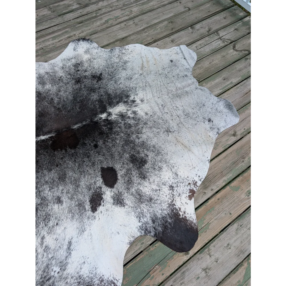 T10 81 x 61 large cowhide rug with natural white and black colors and unique characteristics in texture and shape