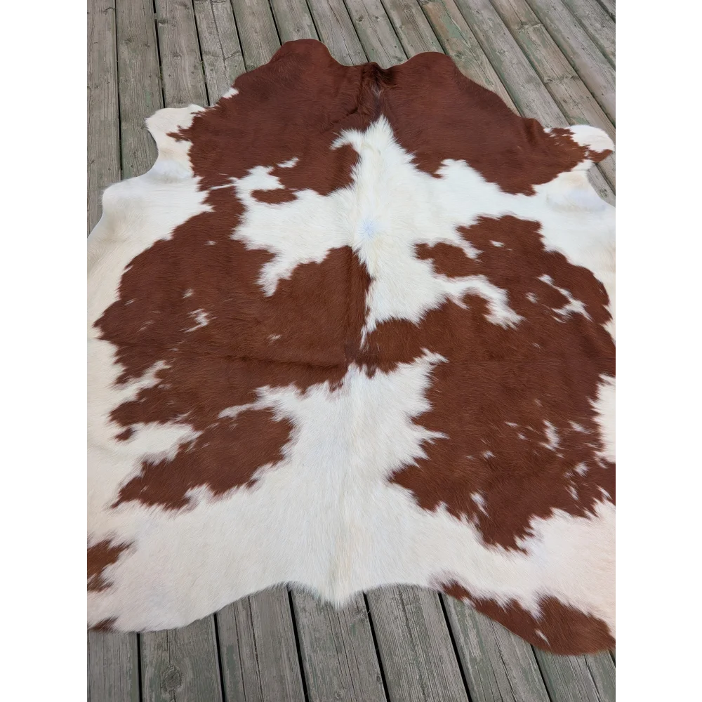 Large brown and white cowhide rug with natural fur texture showcasing unique characteristics in 75 by 69 size