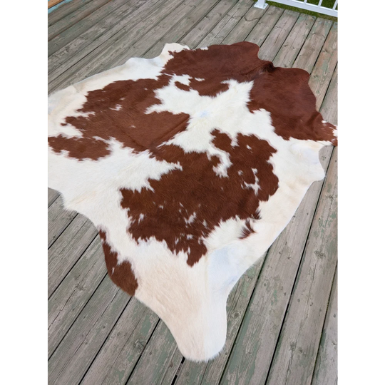 T11 large cowhide rug featuring brown and white natural fur texture with unique characteristics, measuring 75 by 69 inches