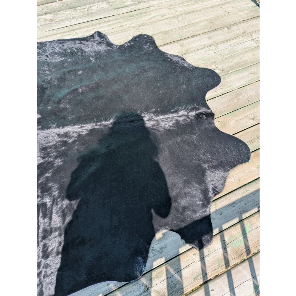 Large black and white angus oliver cowhide rug with natural irregular edges perfect as a stylish floor cover
