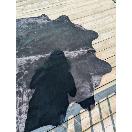 Large black and white angus oliver cowhide rug with natural irregular edges perfect as a stylish floor cover