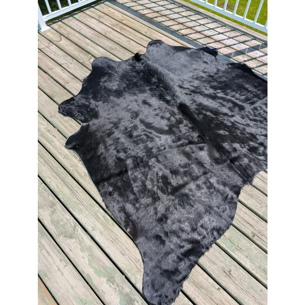 Large black cowhide rug with natural texture and subtle grayish undertones by angus oliver t14 75 x 69