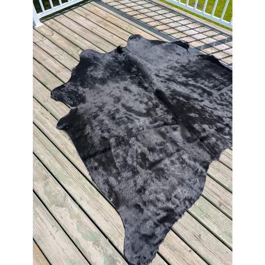 Large black cowhide rug with natural texture and subtle grayish undertones by angus oliver t14 75 x 69
