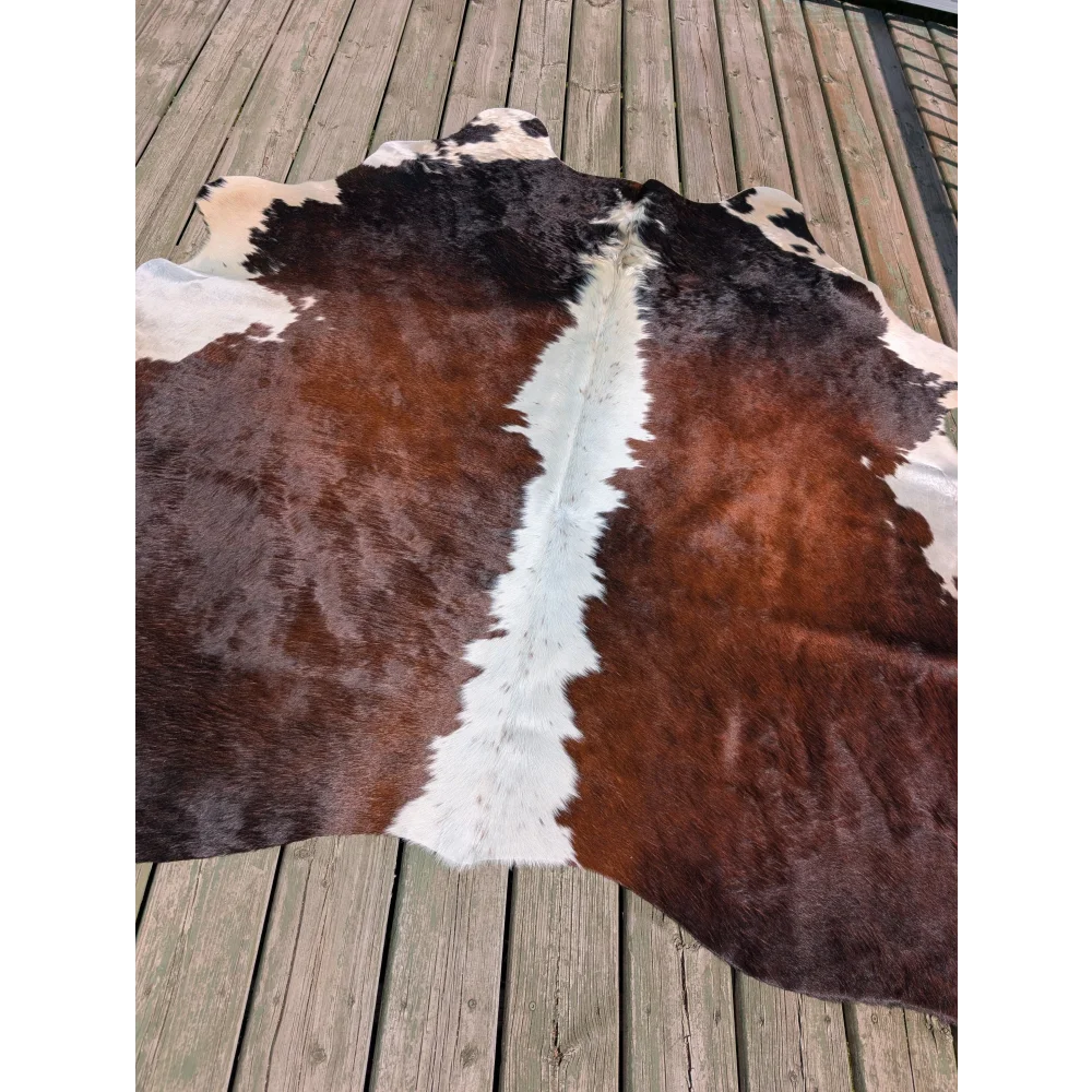 Large cowhide rug angus oliver with natural irregular brown and white pattern measuring 74 by 65 inches