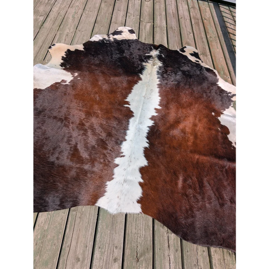 Large cowhide rug angus oliver with natural irregular brown and white pattern measuring 74 by 65 inches