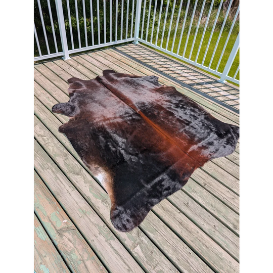 Large cowhide rug 78 x 64 with irregular shape and mottled dark brown black warm orange brown patches angus oliver