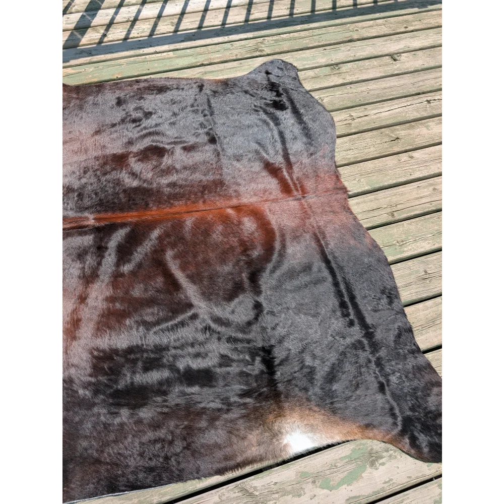 T16 78 x 64 large cowhide rug featuring natural irregular shape with dark brown to black and reddish angus oliver fur