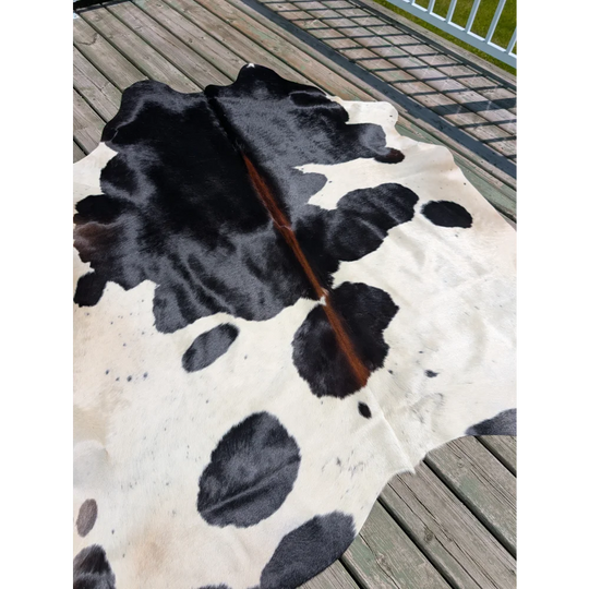 Large black and white cowhide rug with natural fur texture perfect for stylish home decor angus oliver