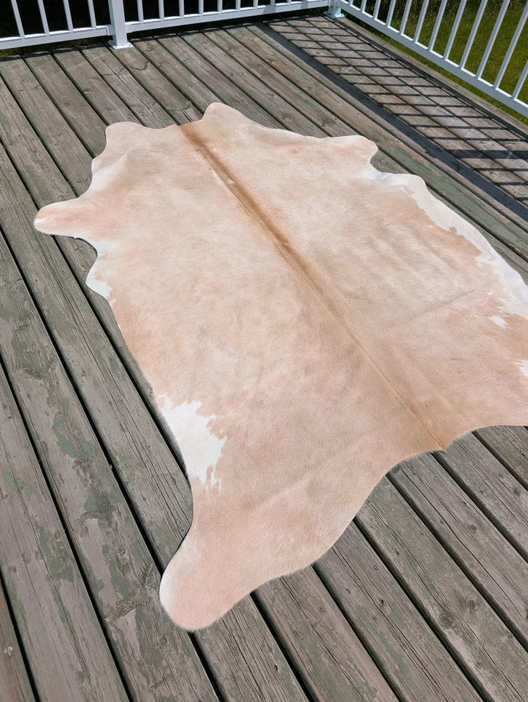 Beige and white large cowhide rug with natural irregular edges from angus oliver perfect for stylish spaces