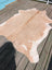 T#18 77 x 63 gorgeous large cowhide rug in natural tan and white by angus oliver on a wooden deck