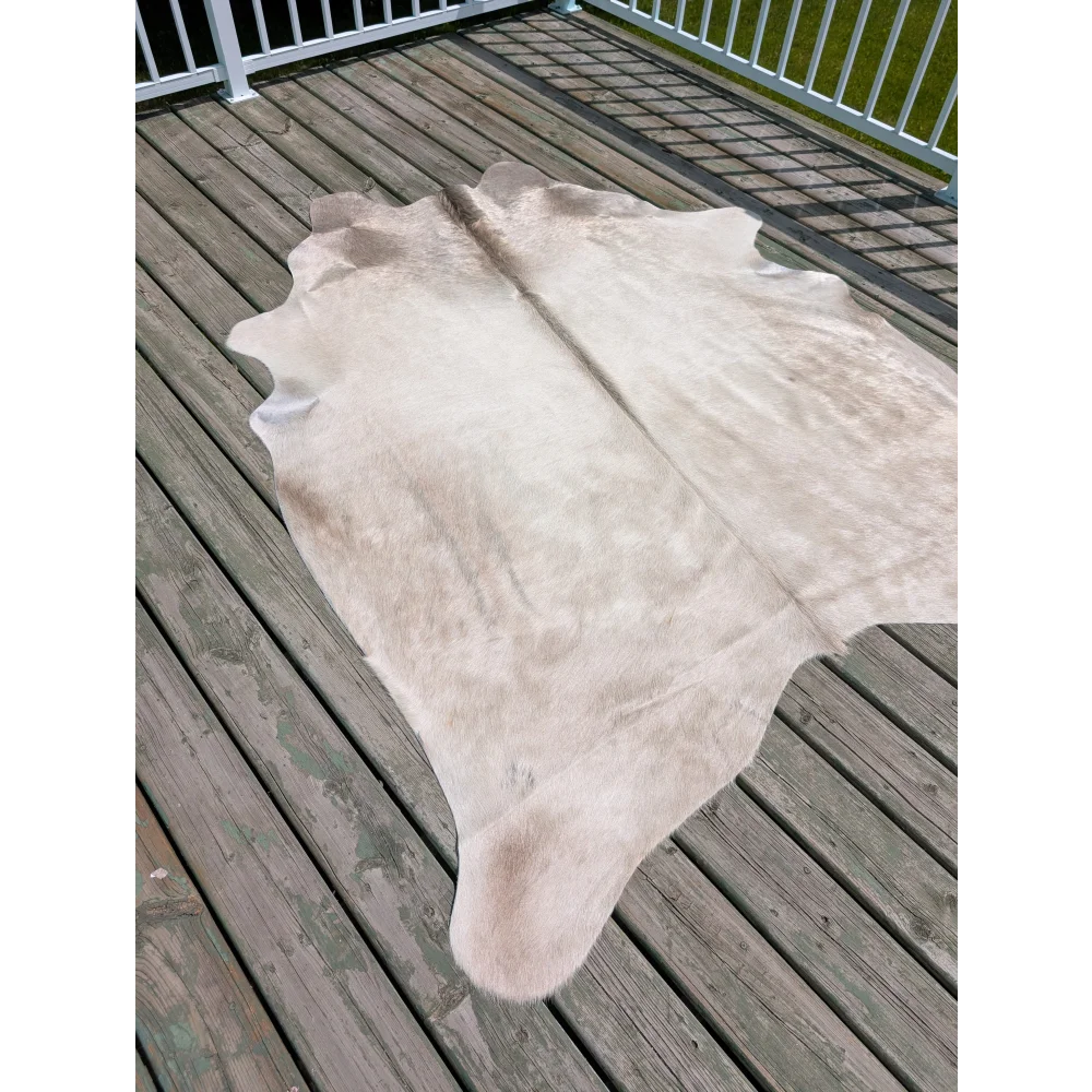 T20 82 x 63 large cowhide rug by angus oliver in natural light beige with soft texture and irregular edges