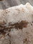A large cowhide rug t21 72 x 62 with white and brown spots and a natural textured surface by angus oliver